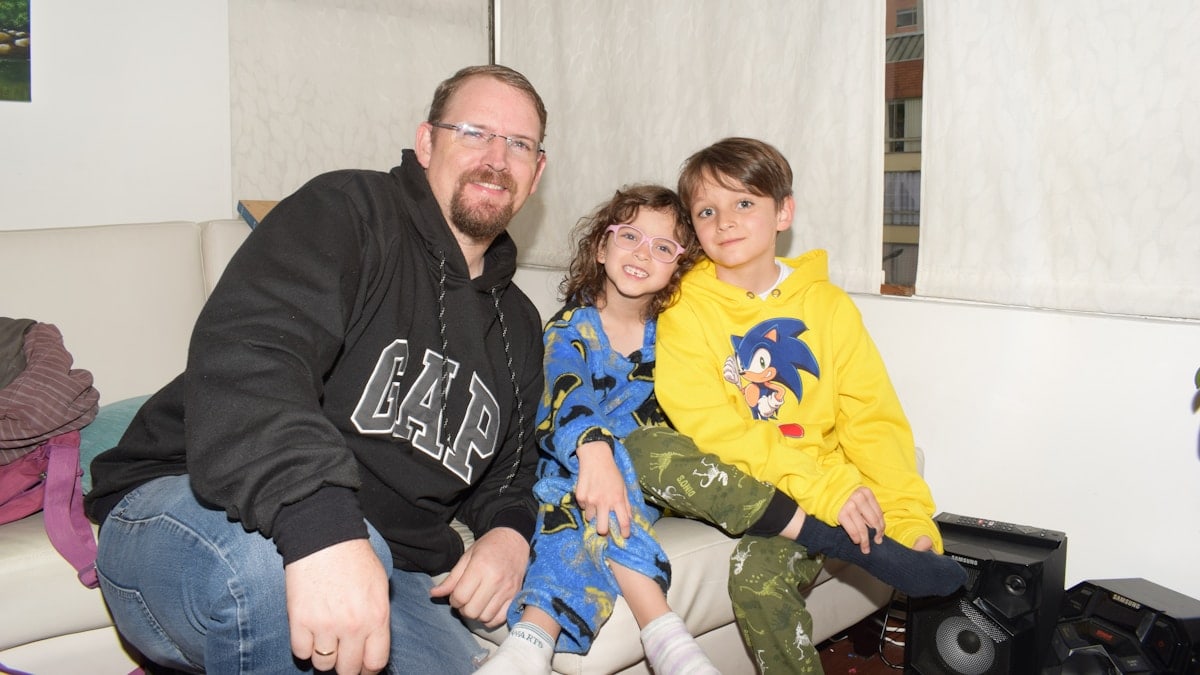 A man and two children sitting on a couch